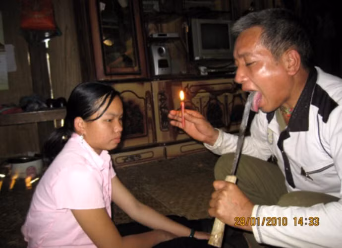 Tổng cộng hơn ba mươi lần dùng ống hút làm như vậy, ông lang đã rút ra được hơn 30 mảnh đạn súng kíp găm khắp người anh thanh niên dân tộc Thái. Không hề thấy có một vết máu nào xuất hiện, sắc mặt anh thanh niên đã bớt tím tái hơn. Tiếp đó, ông bảo người nhà đi xuống bếp lấy con dao phay đang nung đỏ rực trong bếp lò. Cầm con dao đang cháy, ông thản nhiên lè lưỡi liếm vào sống dao và quay lại thổi phù vào mặt bệnh nhân. Anh bạn đồng nghiệp ngạc nhiên đến há hốc cả miệng khi mỗi lần ông lang liếm dao.