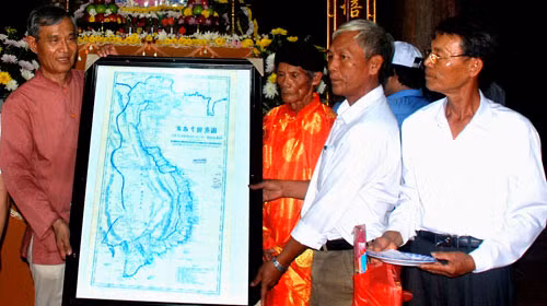 TS Nguyễn Nhã - nhà nghiên cứu Hoàng Sa - tặng phiên bản An Nam đại quốc họa đồ cho tộc họ Phạm Văn ở Lý Sơn (Quảng Ngãi). Bản đồ này xuất bản năm 1838 có vẽ chính xác tọa độ Hoàng Sa, khẳng định chủ quyền của Việt Nam - Ảnh: TT