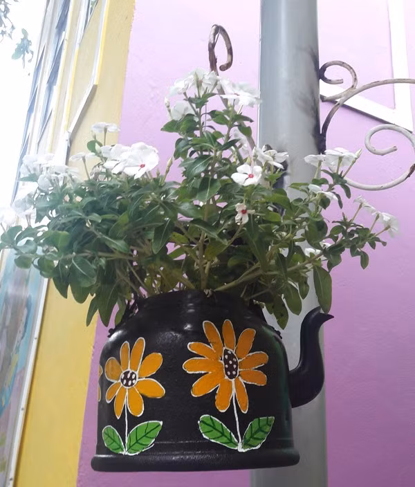 Một chiếc ấm hỏng đã được tô vẽ, tái chế thành một "chậu hoa" đặc sắc.