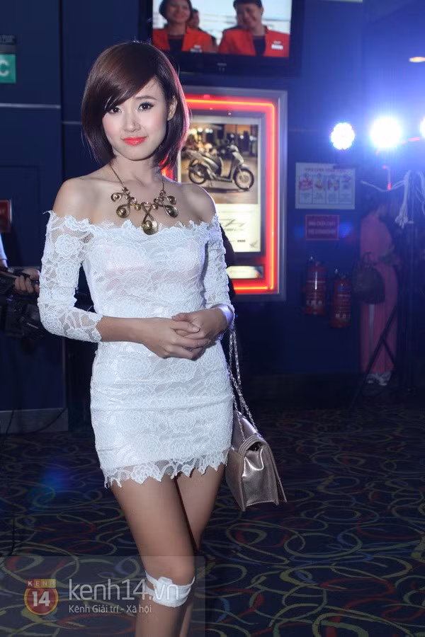 Midu diện đầm trắng khá ngắn, để lộ đầu gối đang được băng bó.