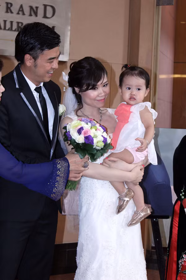 Dù đang mặc soire nhưng cô dâu vẫn không ngại bế con của một người bạn