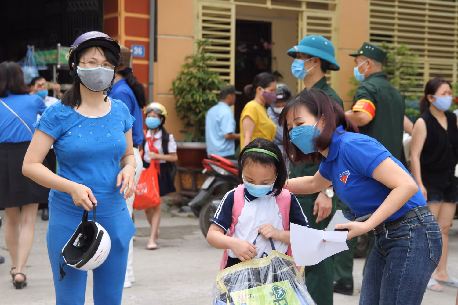 Từ sớm phụ huynh Trường Tiểu học Long Biên đưa con đến cổng trường được thầy cô giáo đón. Ảnh: Vũ Phương