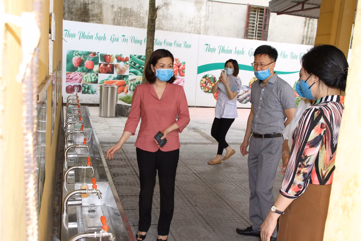 Bà Đinh Thị Thu Hương, Phó Chủ tịch Ủy ban nhân dân quận Long Biên kiểm tra khu vực rửa tay cho học sinh. Ảnh: Vũ Phương.