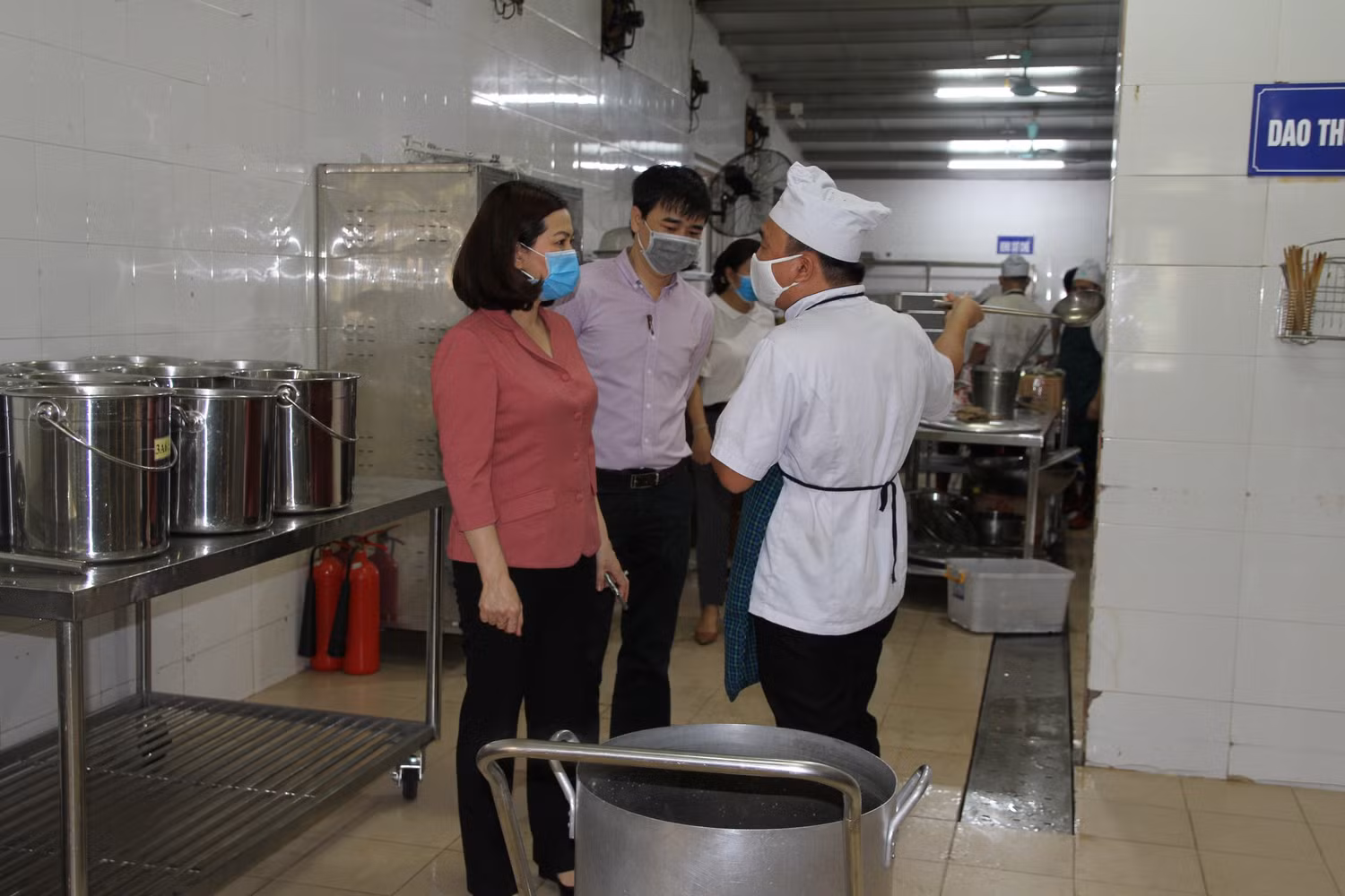 Bà Hương trao đổi với bếp trưởng nhà ăn Trường tiểu học Long Biên về công tác chế biến bữa ăn bán trú cho học sinh ngày đầu trở lại trường. Ảnh: Vũ Phương.